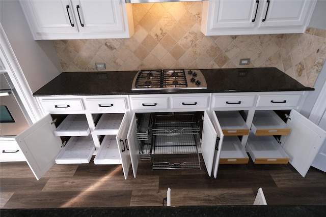 kitchen featuring dark countertops, stainless steel gas stovetop, dark wood-style floors, and white cabinets