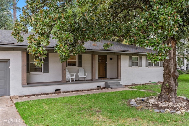 view of front of house with a porch, a garage, and a front lawn