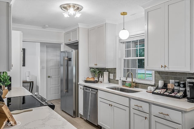 kitchen featuring white cabinetry, appliances with stainless steel finishes, decorative light fixtures, and sink