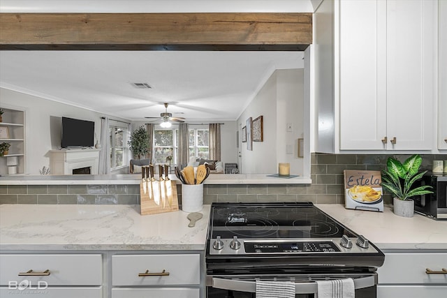 kitchen with light stone countertops, electric stove, decorative backsplash, white cabinets, and ornamental molding