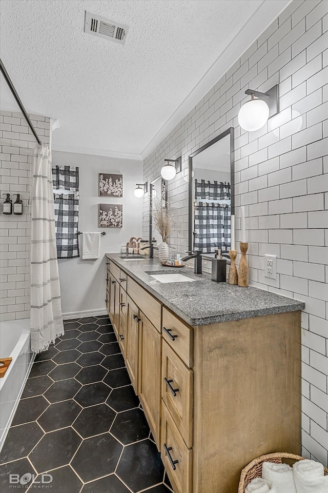 bathroom with vanity, shower / tub combo, and a textured ceiling