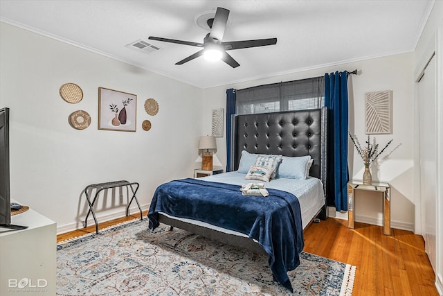 bedroom with a textured ceiling, hardwood / wood-style flooring, ceiling fan, and ornamental molding