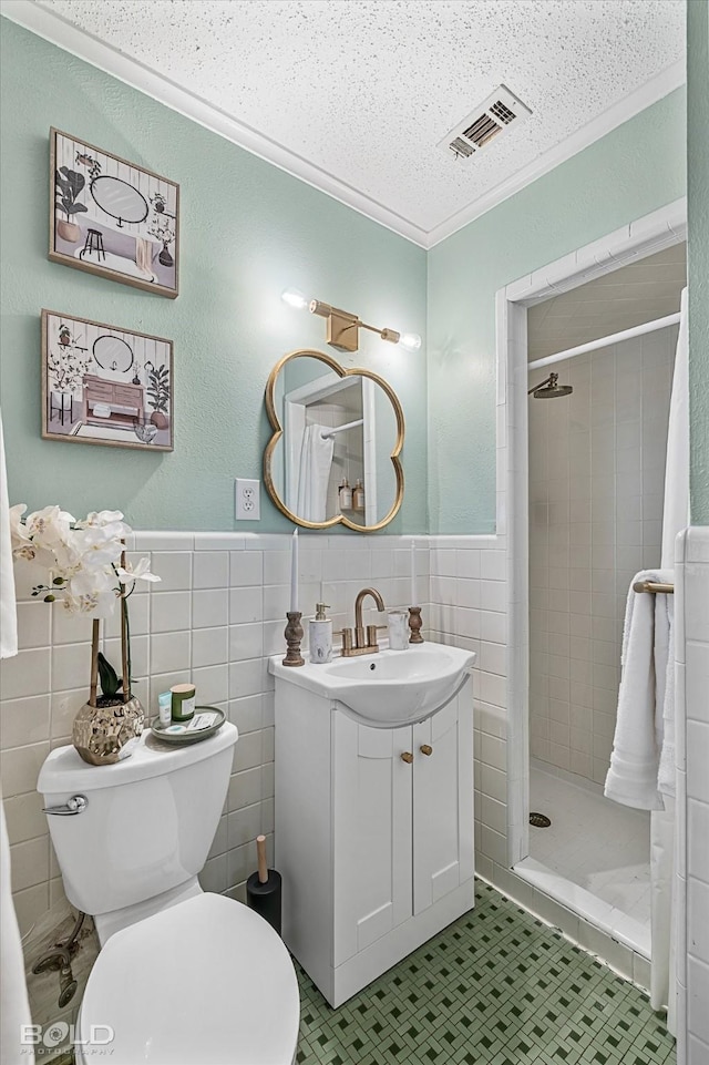 bathroom with tile walls, a shower with shower curtain, vanity, a textured ceiling, and toilet