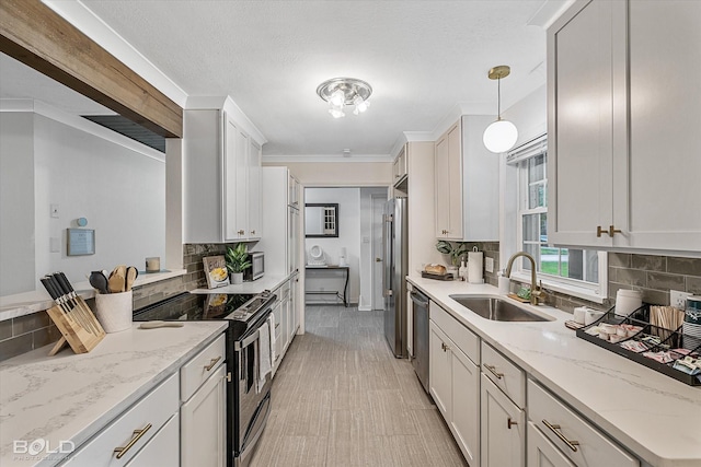 kitchen featuring sink, white cabinetry, stainless steel appliances, and hanging light fixtures