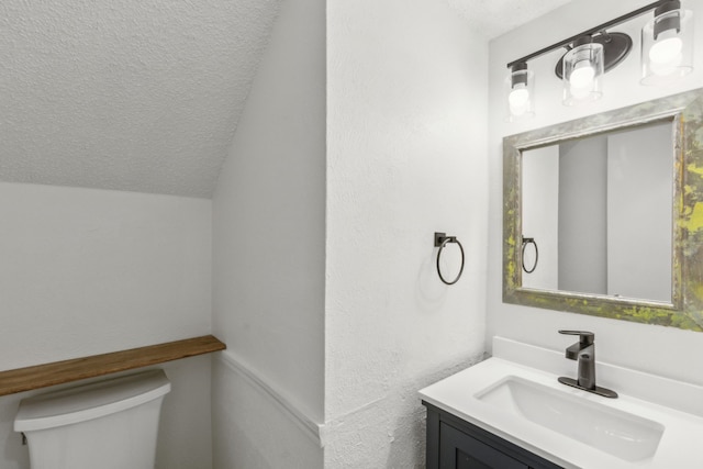 bathroom with vanity, vaulted ceiling, and toilet