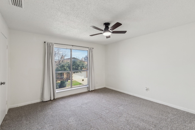 carpeted empty room featuring ceiling fan and a textured ceiling