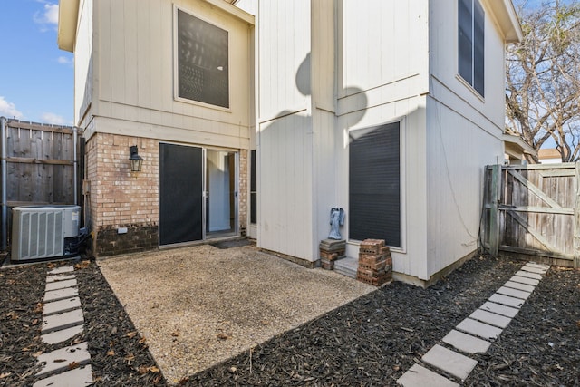 rear view of house with central AC and a patio area