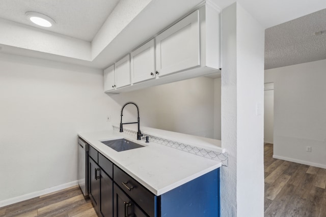 kitchen featuring a textured ceiling, dark hardwood / wood-style floors, white cabinetry, and sink