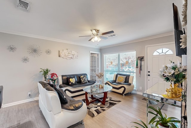 living room featuring ceiling fan, ornamental molding, and light hardwood / wood-style floors