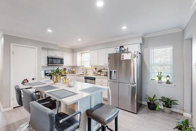 kitchen featuring white cabinets, stainless steel appliances, a wealth of natural light, and sink