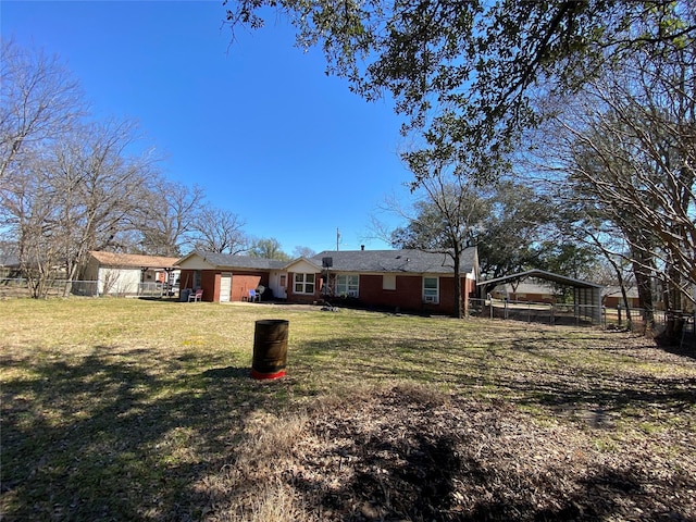 exterior space featuring a carport, a lawn, and fence