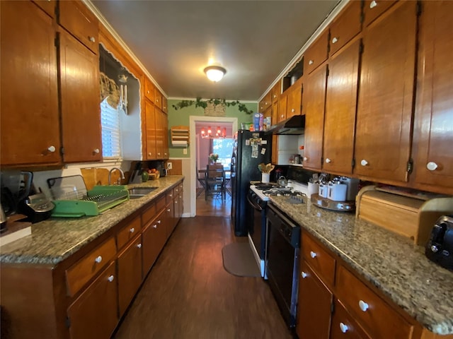 kitchen featuring brown cabinets, crown molding, dark wood finished floors, a sink, and black appliances