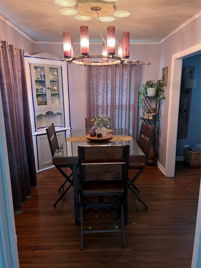 dining area featuring an inviting chandelier, ornamental molding, and dark hardwood / wood-style floors