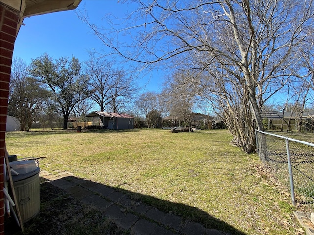 view of yard with a storage shed, fence, and an outbuilding