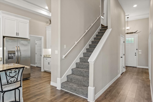 stairway featuring recessed lighting, baseboards, and wood finished floors