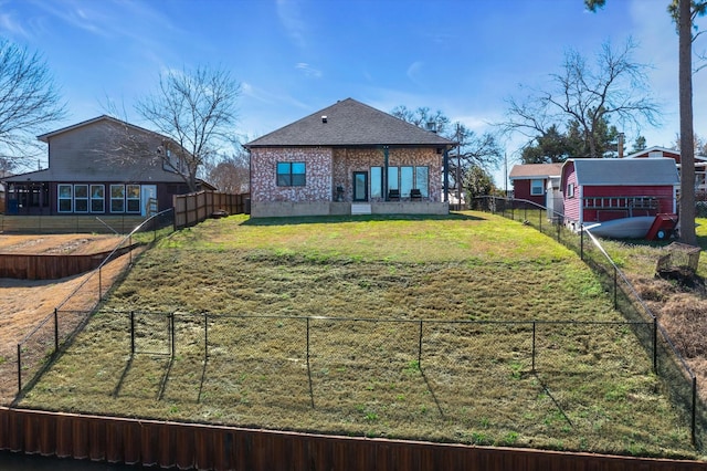 rear view of property featuring a fenced backyard and brick siding