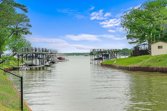 dock area featuring a water view, fence, and boat lift