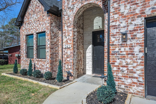 entrance to property featuring brick siding