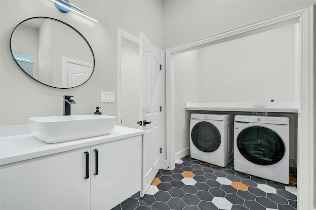 washroom with cabinets, washer and clothes dryer, and sink