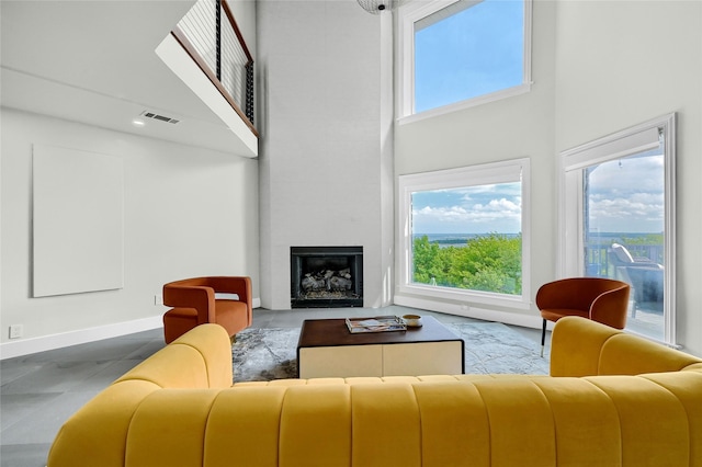 living room featuring a towering ceiling and a large fireplace