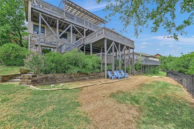 back of house featuring a lawn and a deck