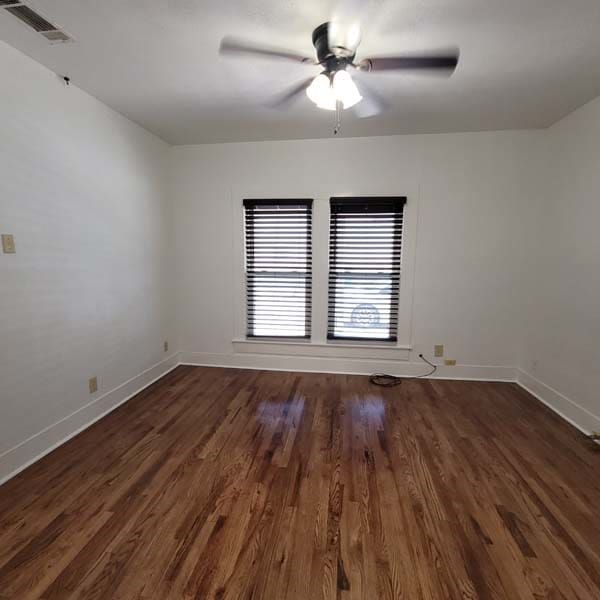 empty room with dark hardwood / wood-style floors and ceiling fan