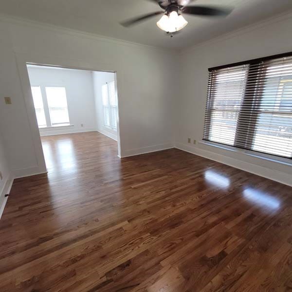 unfurnished room with ceiling fan, crown molding, and dark hardwood / wood-style floors