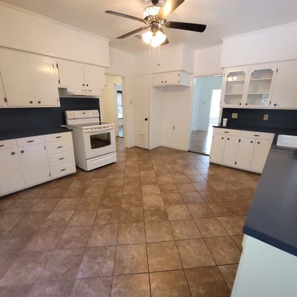 kitchen with electric stove, white cabinetry, ceiling fan, and range hood