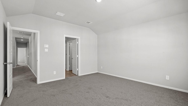 unfurnished bedroom featuring dark carpet and lofted ceiling