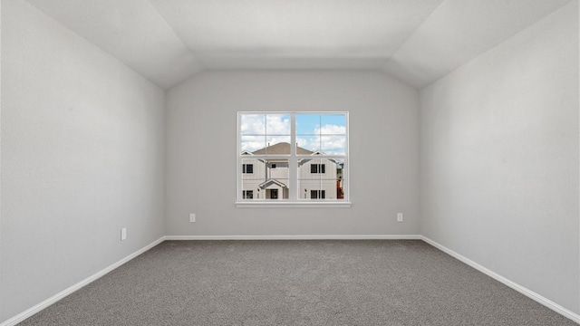 carpeted spare room featuring vaulted ceiling