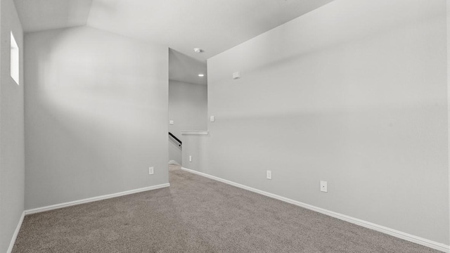 unfurnished room with carpet flooring and lofted ceiling