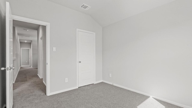 unfurnished bedroom featuring lofted ceiling, carpet floors, and a closet