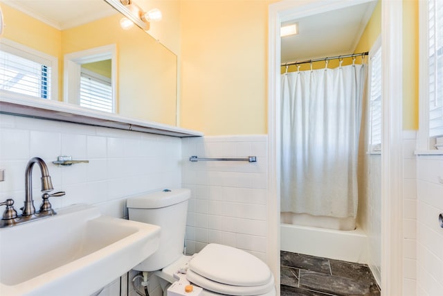 full bathroom featuring toilet, sink, shower / bath combo with shower curtain, and tile walls