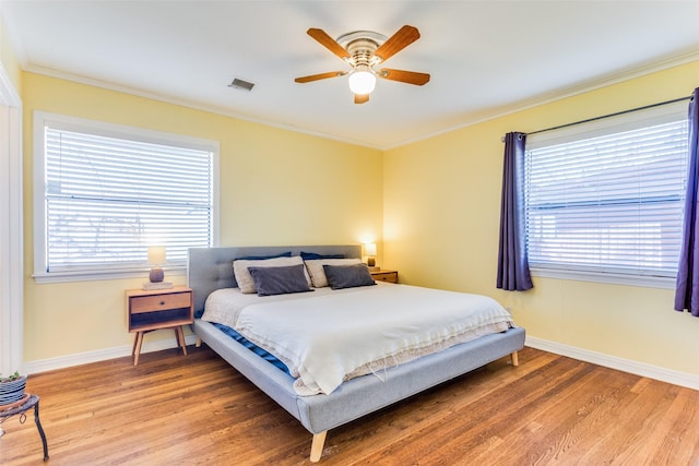 bedroom featuring hardwood / wood-style floors, ceiling fan, and ornamental molding