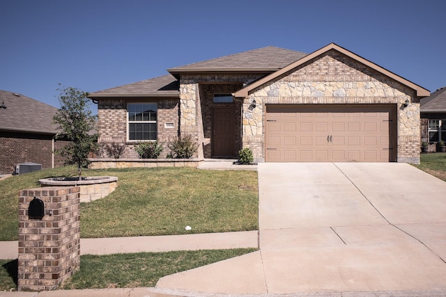 view of front of home with central AC unit, a front yard, and a garage