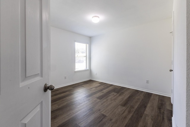 spare room featuring dark wood-type flooring