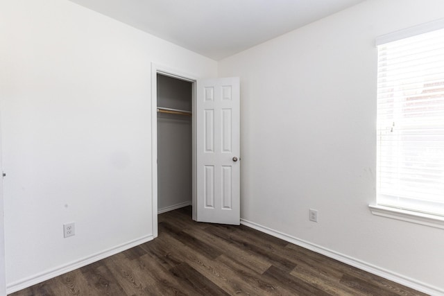 unfurnished bedroom featuring dark wood-type flooring and a closet