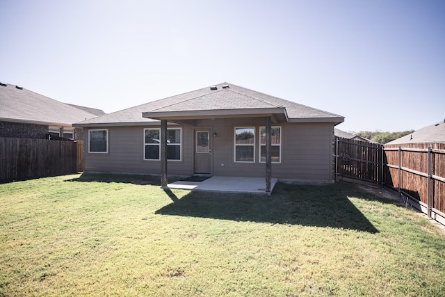 rear view of house with a yard and a patio