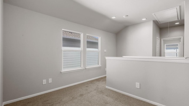 hallway with a wealth of natural light, carpet floors, and vaulted ceiling