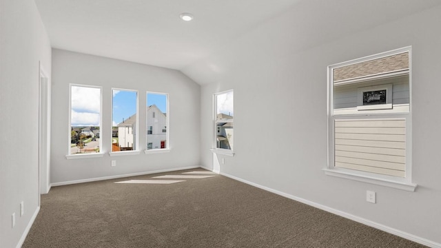 carpeted spare room with vaulted ceiling