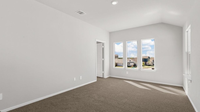 spare room featuring carpet floors and vaulted ceiling