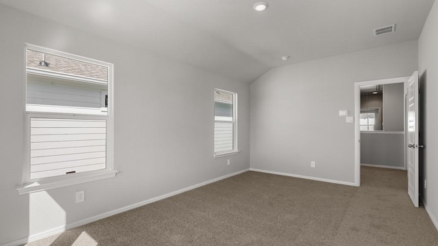 empty room with lofted ceiling and carpet flooring