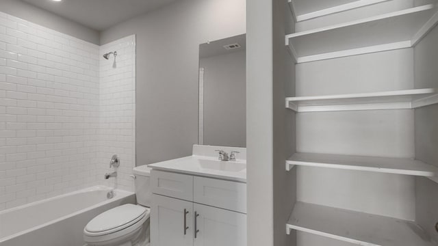 full bathroom featuring tiled shower / bath, vanity, and toilet