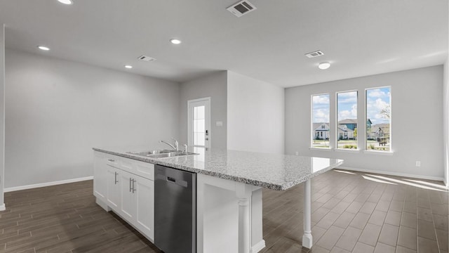 kitchen featuring stainless steel dishwasher, sink, white cabinets, and a kitchen island with sink