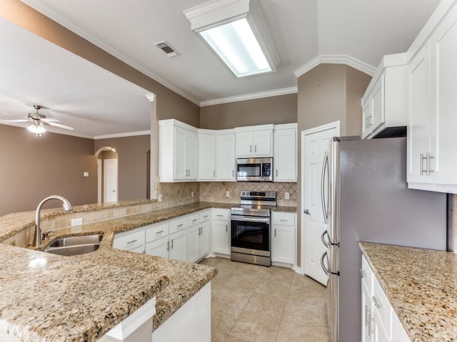 kitchen featuring appliances with stainless steel finishes, kitchen peninsula, sink, and light stone countertops