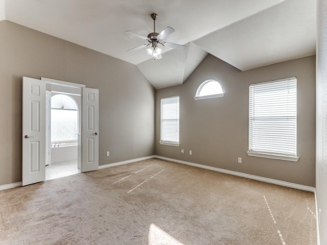 carpeted spare room featuring lofted ceiling and ceiling fan