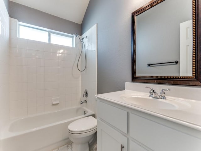 full bathroom featuring tiled shower / bath combo, vanity, vaulted ceiling, and toilet