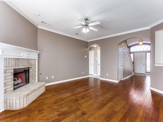 unfurnished living room featuring ceiling fan, ornamental molding, a fireplace, and dark hardwood / wood-style flooring