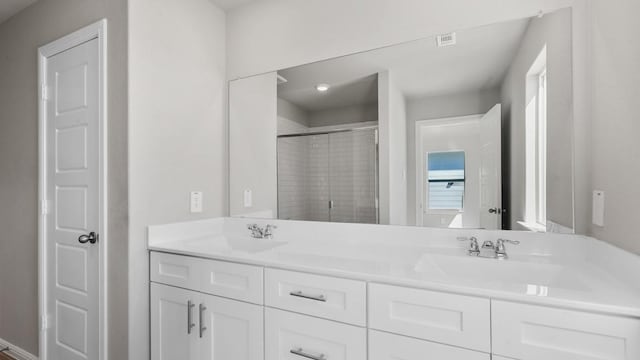 bathroom with vanity and a shower with shower door