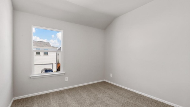 unfurnished room featuring carpet and vaulted ceiling